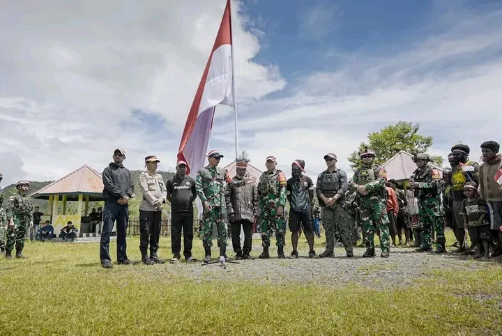Bersama Masyarakat, Satgas Yonif 715/Motuliato dan Apkam Puncak Jaya Kibarkan Bendera Merah Putih Raksasa di momen tanggal 1 Mei 2025
