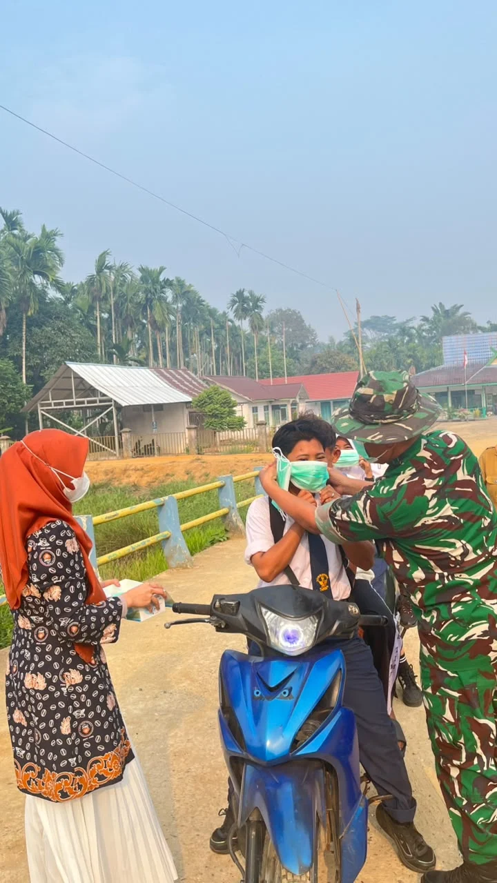 Bersama tenaga PusKesMas .Babinsa Koramil 04/Nipah Panjang bagi Masker  cegah dampak kabur asap.
